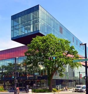 a glass building with a tree in front of it