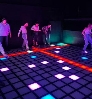 a group of people standing in a room with lights