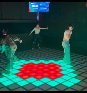 a group of people standing in a room with a lighted floor