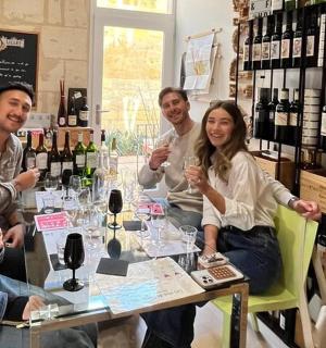 a group of people sitting around a table with wine glasses