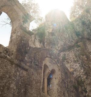 a person standing in the doorway of a stone building