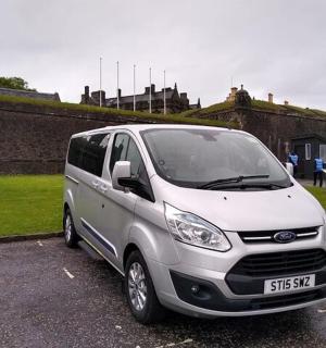 a white van parked in a parking lot next to a statue