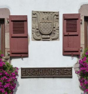 a sign on the side of a building with flowers