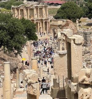 a group of people walking through the ruins of the ancientropolis
