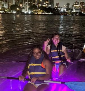 Dva lidé sedí v noci v lodi na vodě