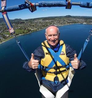 一名身穿救生衣的男子在水面上的降落伞上