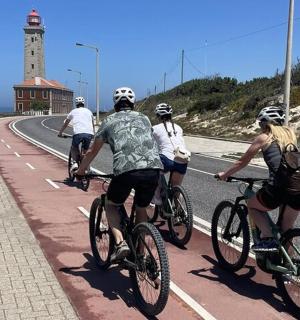 一群人骑着自行车沿着有灯塔的道路行驶