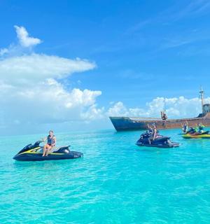 skupina lidí jedoucích na kánoích v oceánu s lodí