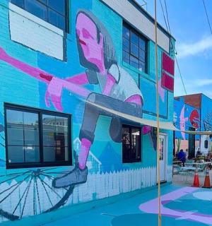 a mural of a woman on a bike on the side of a building
