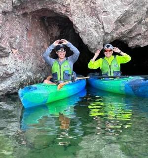 两个人在洞穴前的皮划艇上