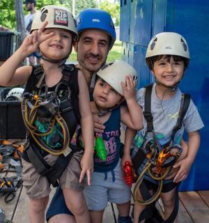 a man and two children with helmets on their heads