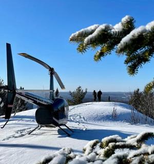 sebuah helikopter yang duduk di atas bukit yang dilitupi salji