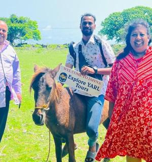 三个人站在一匹马旁边