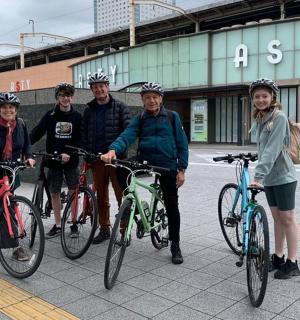 一群人带着自行车站在一栋建筑前