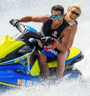 a man and a woman riding on a jet ski