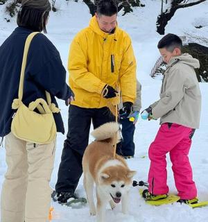 a group of people standing in the snow with a dog