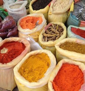 a display of different colored spices in baskets