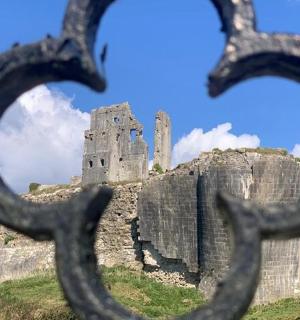 a castle seen through the iron bars of a fence