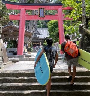 two people walking up some stairs with surfboards