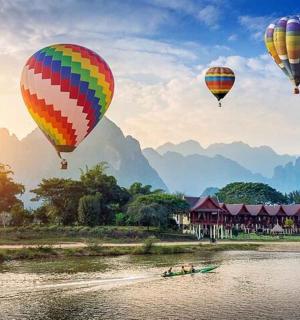 三个热气球飞越河流