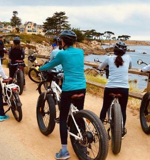 a group of people riding bikes on the beach
