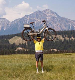 一名男子在田野里头顶着一辆自行车