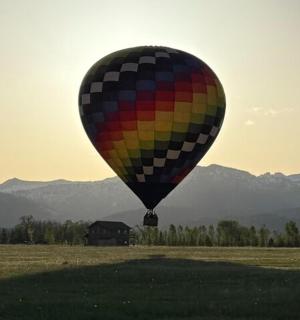 värviline kuumaõhupall lendab üle põllu