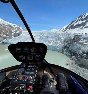 驾驶直升机飞越山脉的人