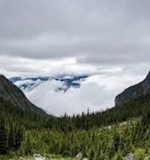 pohled na horské údolí se stromy a mraky