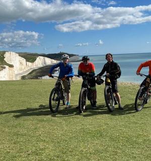 一群人在白色悬崖附近的草地上骑自行车