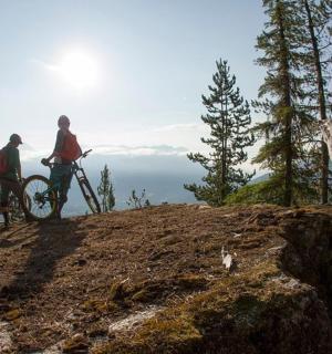 dva lidé stojící na kopci se svými koly