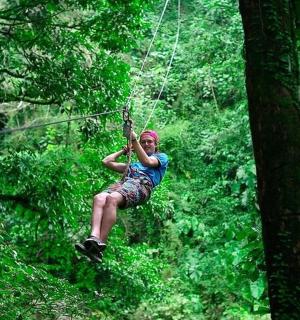 一个人在森林里悬挂在滑索上