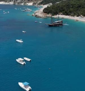 a group of boats in the water next to a beach