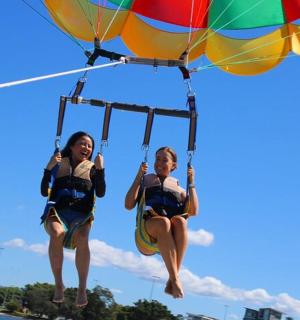 two girls are riding on a parachute