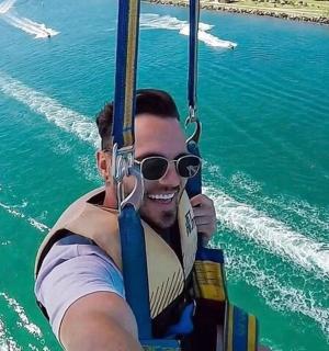 a man in a life vest on a zip line over the water