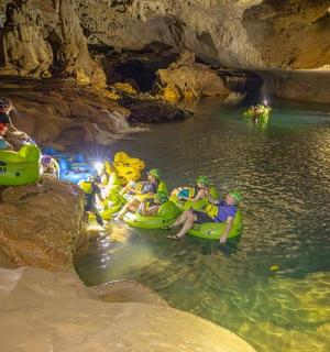 一群人坐在洞穴里的木筏上