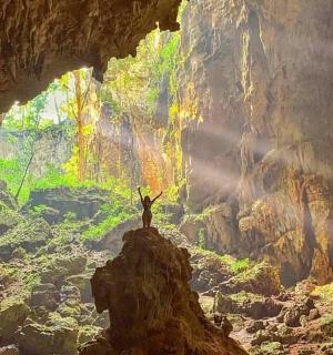 a person standing on a rock in a cave
