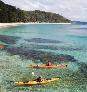 dva lidé v kajacích ve vodě poblíž pláže