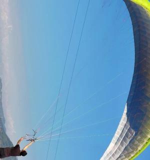 a man is holding onto a large green kite