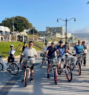 a group of people riding bikes down a sidewalk