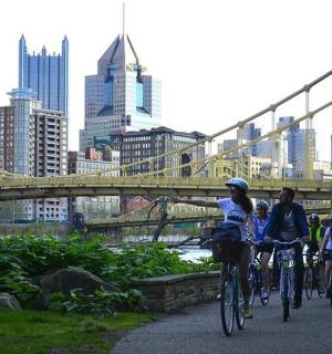 skupina lidí jedoucích na kolech na mostě