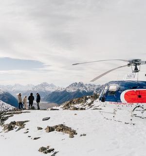 a helicopter parked on top of a snow covered mountain