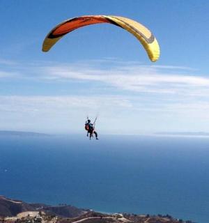 带着降落伞在空中飞行的人