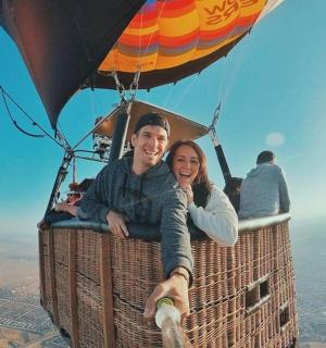 a man and woman riding in a hot air balloon