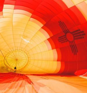 člověk stojí uvnitř horkovzdušného balónu