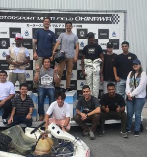 一群人在一辆摩托车旁摆姿势拍照