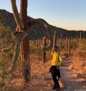 muž stojí vedle saguaroktu