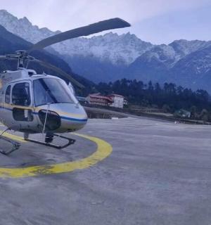 一架直升机停在跑道上，背景是群山