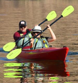 a man and a woman in a kayak on the water