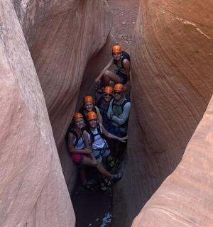 a group of people standing in a slot canyon